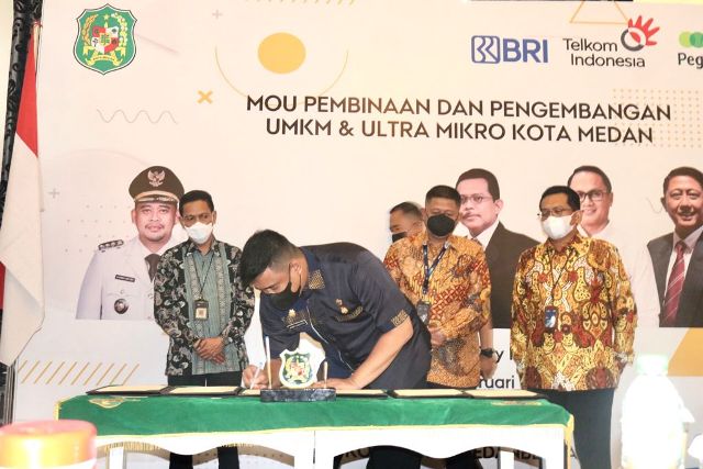 Wali Kota Medan, Bobby Nasution, sedang menandatangani perjanjian kerjasama dengan BRI dan Pegadaian dalam pengembangan UMKM
