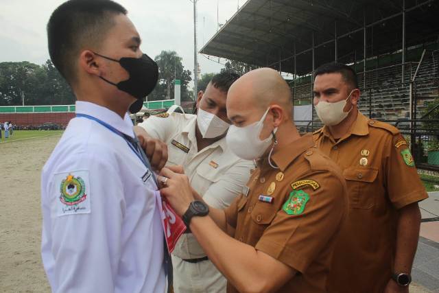 Sekretaris Dispora Medan, Agha Novrian, sedang menyematkan tanda peserta seleksi Paskibra 2022
