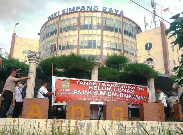 BPPRD Kota Medan memasang spanduk menunggak PBB di Ramayana Yuki Simpang Raya