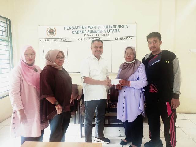 Ketua PWI Sumut, Farianda Putra Sinik, menyerahkan asuransi kepada ahli waris Hembri Ginting