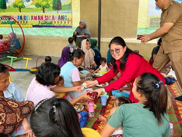 Anggota DPRD Medan Fraksi PDI Perjuangan, Margareth MS, memberikan makanan tambahan kepada balita di Sicanang