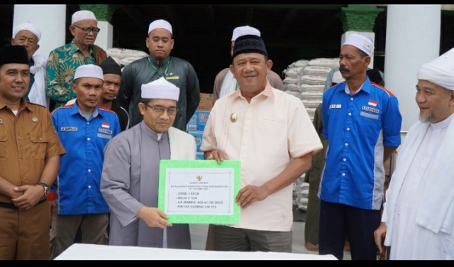 Plt Bupati Langkat, Syah Afandin, menyerahkan bantuan peringatan HAUL Tuan Guru Babussalam, Syekh Abdul Wahab Rokan ke-99 tahun