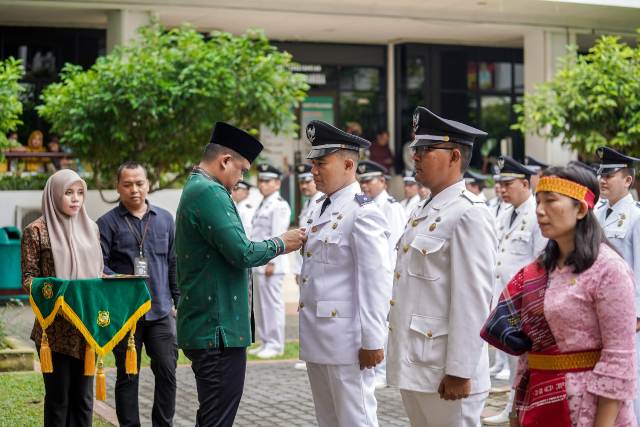 Wali Kota Medan, Bobby Nasution, menyematkan tanda jabatan kepada salah seorang perwakilan pada pelantikan pejabat di Pemkot Medan