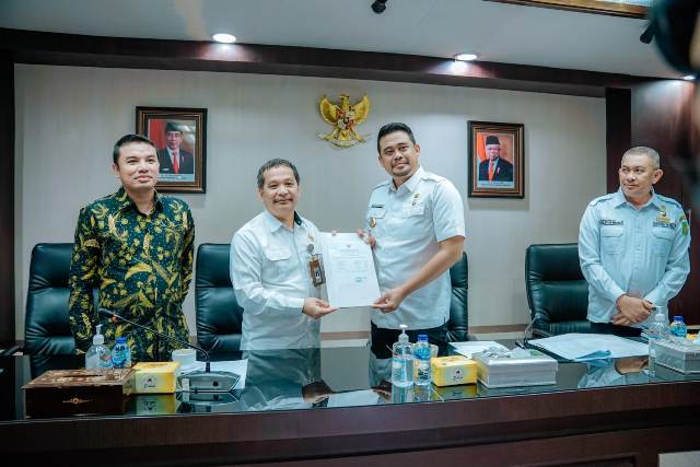 Wali Kota Medan, Bobby Nasution, menyerahkan berkas yang akan diperiksa kepada Ketua BPK RI Perwakilan Sumut, Eydu Oktain Panjaitan