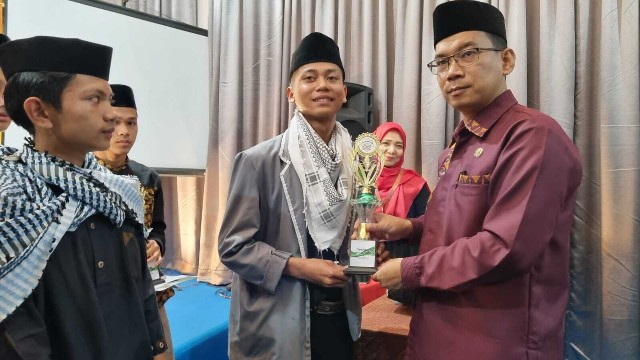 Panitia memberikan piala kepada juara MTQ tingkat SMA di Karo