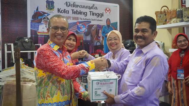 Pj Wali Kota Tebingtinggi, Muhammad Dimiyathi bersama istri, Harliaminda Dimiyathi, memberikan oleh-oleh pada event Inacraft di Jakarta