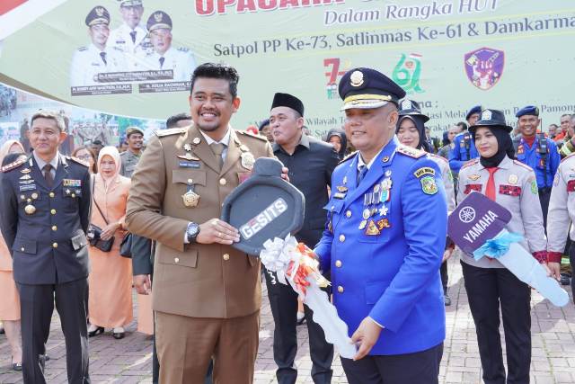 Wali Kota Medan, Bobby Nasution, memberikan kunci kepada Plt Kadis Damkarmat, Muhammad Yunus, pada peringatan HUT Damkarmat ke 104 di Lapangan Benteng Medan