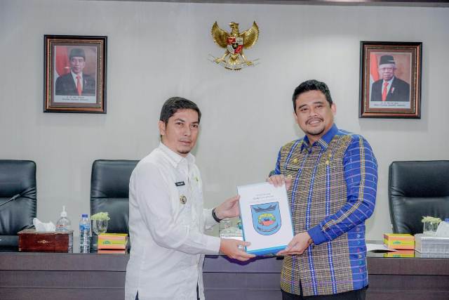 Wali Kota Medan, Bobby Nasution, memberikan buku kepada Wali Kota Sawahlunto, Deri Asta, saat berkunjung ke Balai Kota Medan
