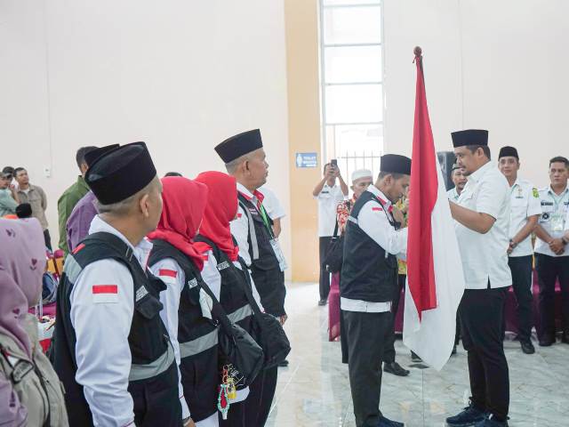 Wali Kota Medan, Bobby Nasution, menyerahkan bendera merah putih saat melepas keberangkatan Calhaj Kota Medan