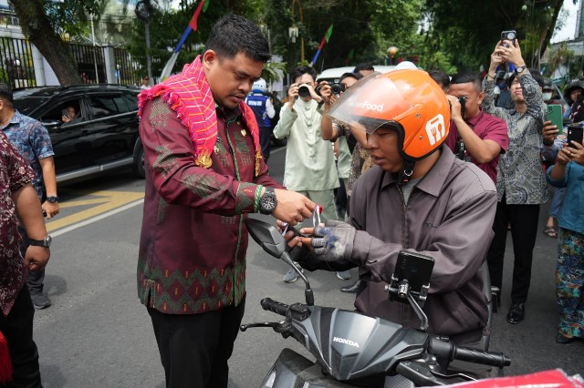 Wali Kota Medan, Bobby Nasution, bagikan bendera kepada pengendara