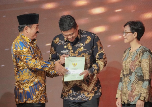 Wali Kota Medan, Bobby Nasution, menerima sertifikat tanah dari Menteri ATR RI, Hadi Tjahjanto, di Kantor Gubernur Sumut
