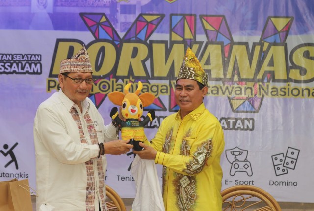 Ketua PWI Kalsel, Zainal Helmie, memberikan maskot Porwanas kepada Ketua Ikasba Kalsel, Arliansyah Mahadi