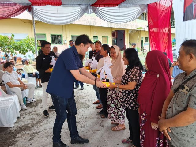 Bendahara Fraksi PSI DPRD Medan, Reinhart Jeremy Anindhita, berikan souvenir usai gelaran Sosper VII TA 2026 di Medan Perjuangan
