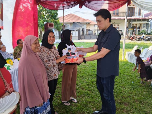Bendahara Fraksi PSI DPRD Kota Medan, Reinhart Jeremy Anindhita, berikan sovenir usai menggelar Sosialisasi Perda ke VIII TA 2026 di Medan Deli