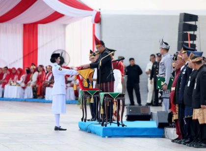 Gubernur Sumut, Bobby Nasution, menyerahkan bendera kepada Paskibra untuk dikibarkan pada upacara HUT RI ke 81