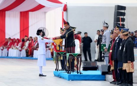 Gubernur Sumut, Bobby Nasution, menyerahkan bendera kepada Paskibra untuk dikibarkan pada upacara HUT RI ke 81
