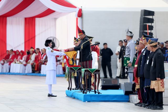 Gubernur Sumut, Bobby Nasution, menyerahkan bendera kepada Paskibra untuk dikibarkan pada upacara HUT RI ke 81