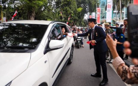 Wali Kota Medan, Rico Tri Putra Bayu Waas, bagikan bendera kepada pengendara
