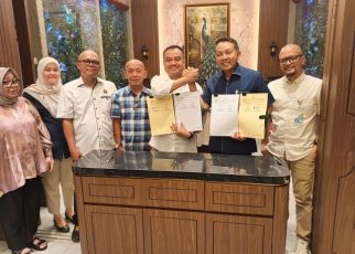 Ketua PWI Sumut, Farianda Putra Sinik dan Kepala Kanwil BPJS Ketenagakerjaan Sumbagut, Kunto Wibowo, perlihatkan draf Perjanjian Kerjasama yang ditandatangani