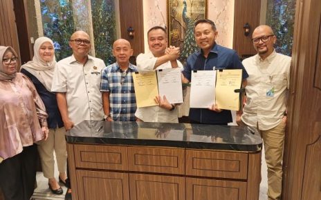Ketua PWI Sumut, Farianda Putra Sinik dan Kepala Kanwil BPJS Ketenagakerjaan Sumbagut, Kunto Wibowo, perlihatkan draf Perjanjian Kerjasama yang ditandatangani