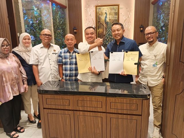 Ketua PWI Sumut, Farianda Putra Sinik dan Kepala Kanwil BPJS Ketenagakerjaan Sumbagut, Kunto Wibowo, perlihatkan draf Perjanjian Kerjasama yang ditandatangani